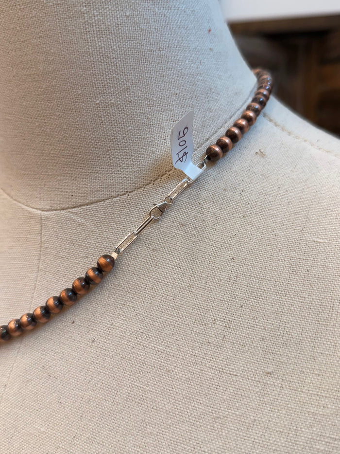 Copper bead necklace with clasp and toggle bar detail on a mannequin