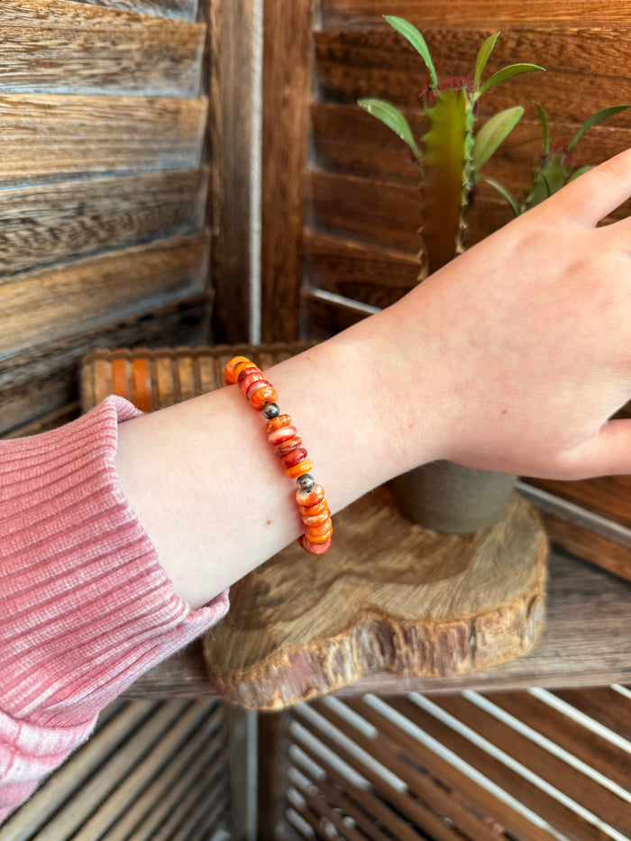 Orange spiny oyster beaded bracelet with sterling pearl accents worn on wrist