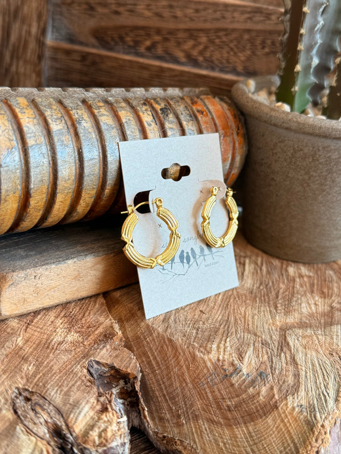 Gold textured wire hoop earrings, angled view on display card