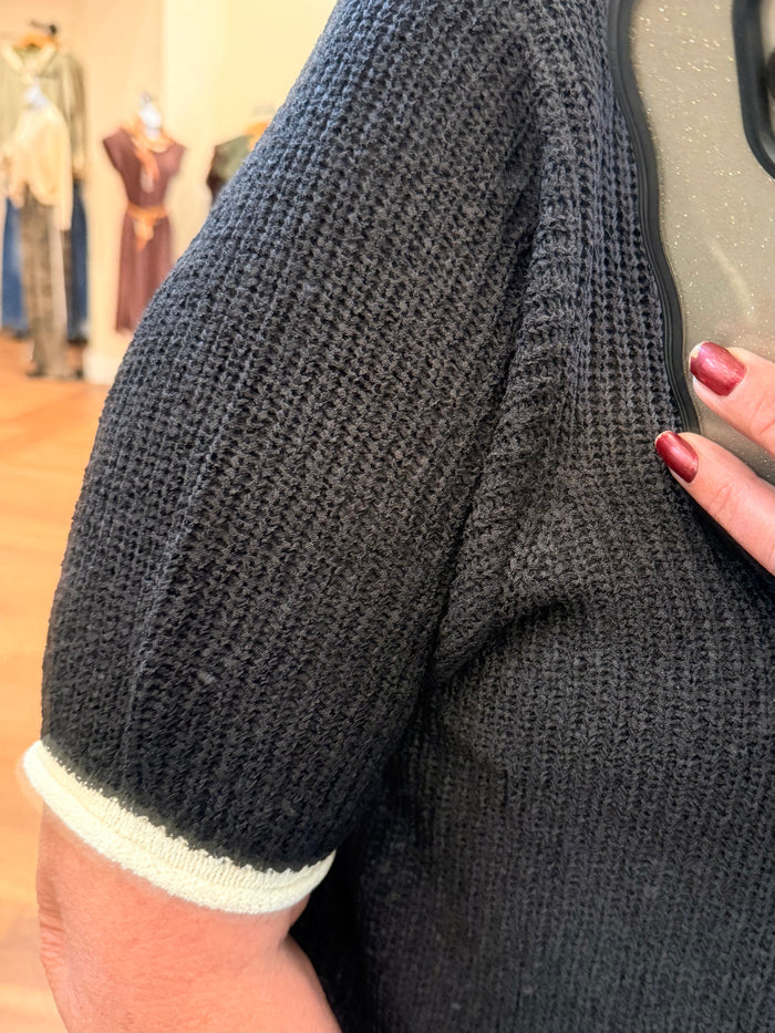Black short-sleeve knit sweater sleeve with white ribbed cuff trim