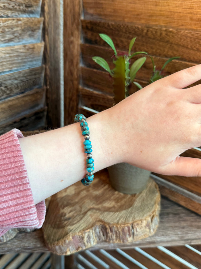 Turquoise bead stretch bracelet worn on wrist