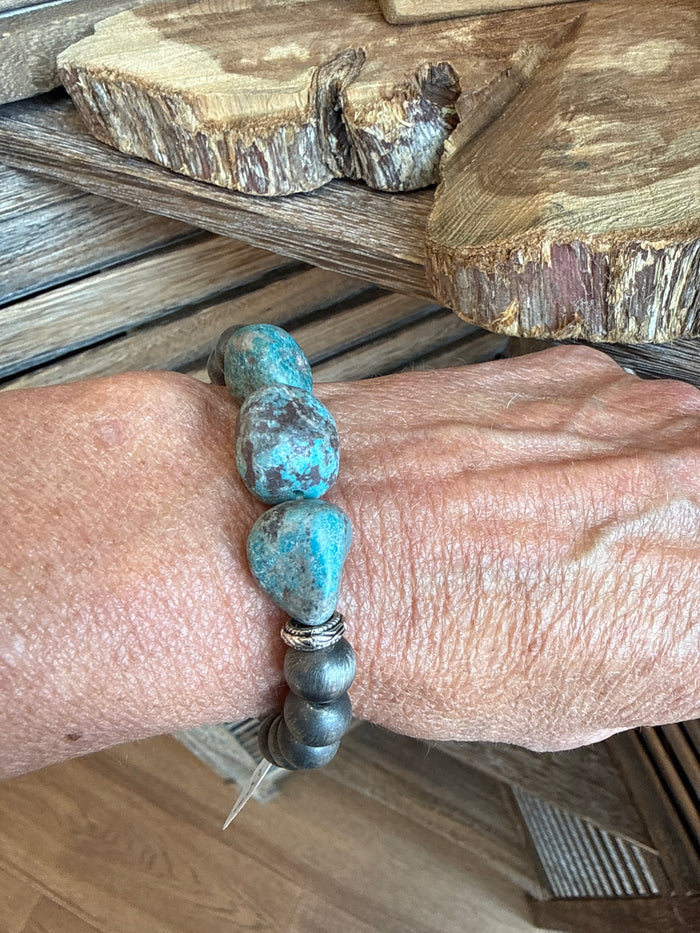 Chunky turquoise arrowhead pearl stretch bracelet with silver-tone bead spacers on wrist