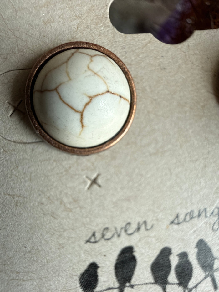 Copper-tone round stud earring with white cracked stone center and copper bezel edge