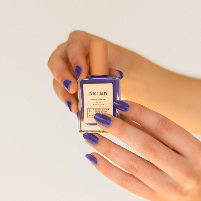 Hands wearing BKIND Berry Kini – Calgary vegan nail polish in a deep purple shade for bold, clean beauty looks.