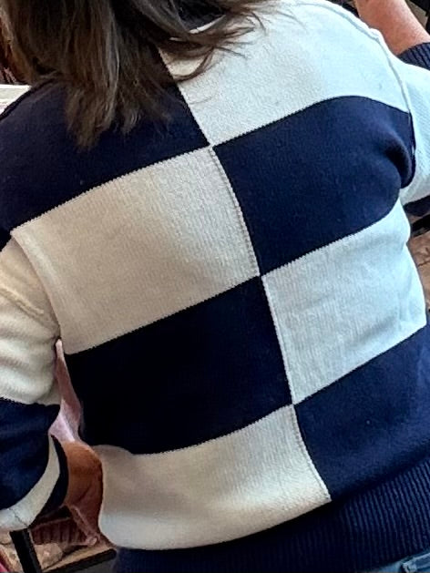 Mock neck checkered sweater with navy and cream blocks, ribbed knit cuffs