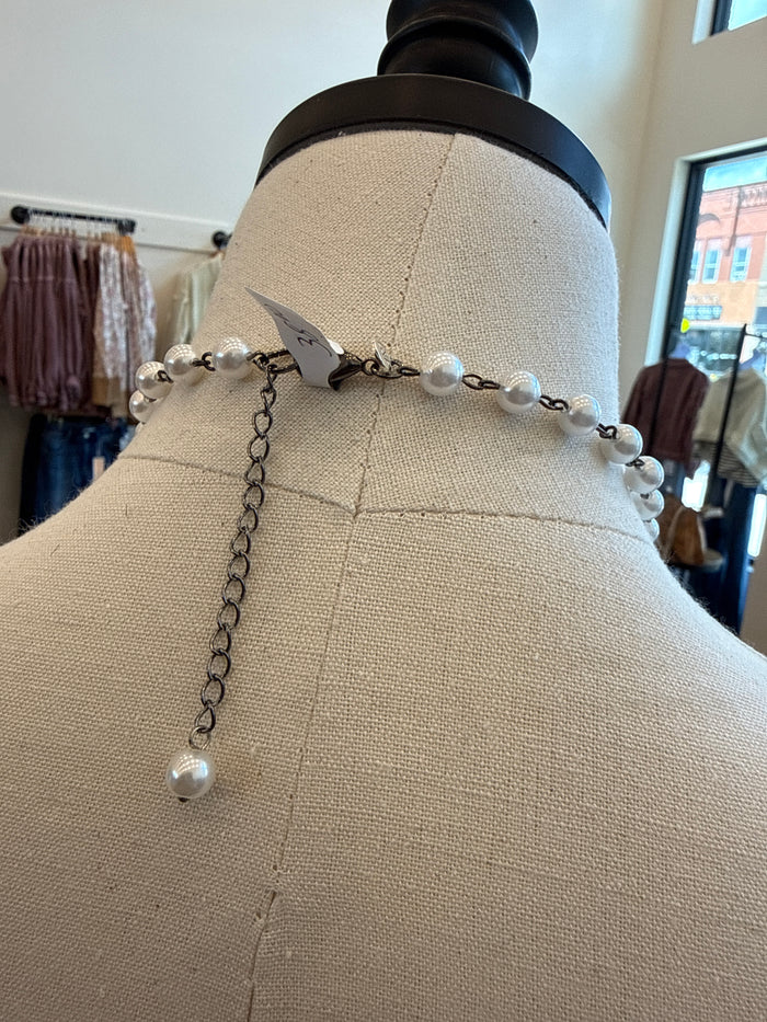 Silver-tone pearl necklace with dangling pearl drops and small crystal butterfly charm