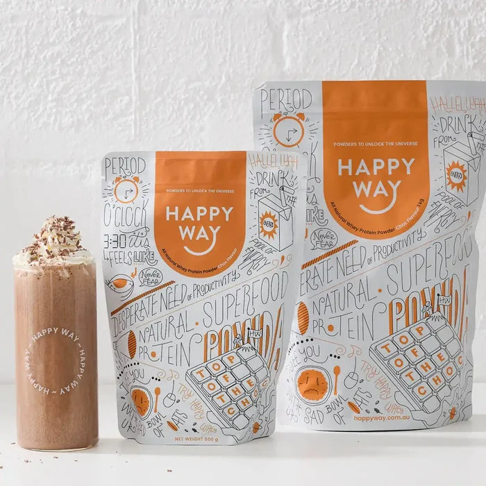 Happy Way chocolate whey protein powder packages next to a chocolate milkshake topped with cream & shaved chocolate.