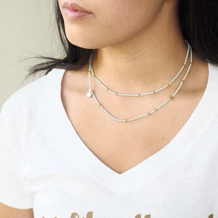 Model wearing the Wonder Wrap Bracelet (White Pearl & Gold Multi) | Love You More, styled as a delicate double-layered necklace with white pearls and gold accents.