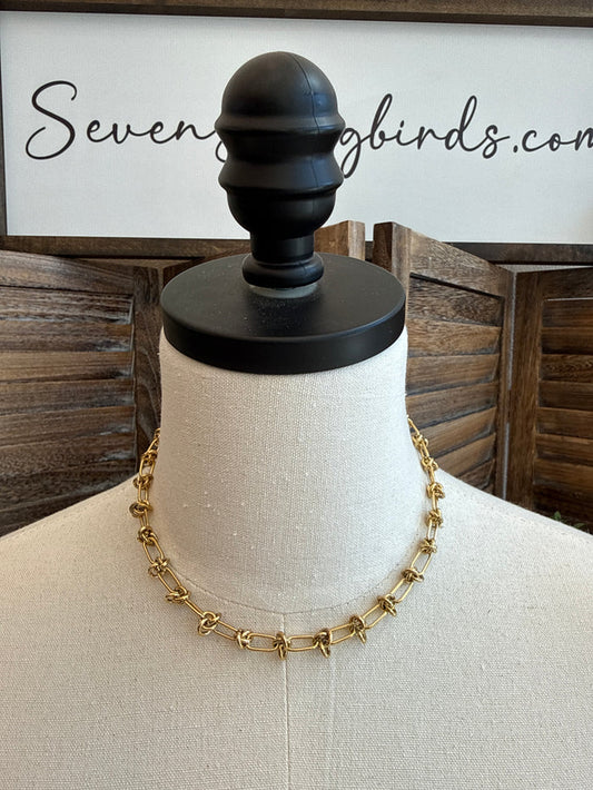 Gold-plated barbedwire-style chain necklace on display head