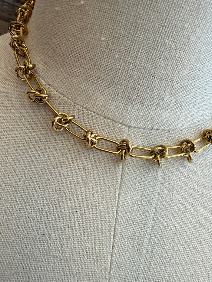 Close-up of gold-plated barbedwire-style chain with interlocking links