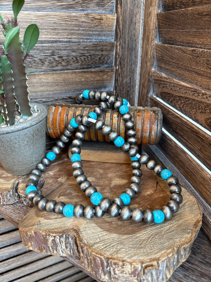 Beaded USB-C phone charger with dark gray beads and small turquoise accents, coiled cable