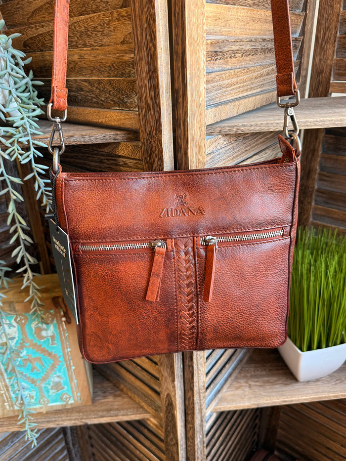 Rusty brown leather crossbody bag with double front pockets and tassel zipper pulls
