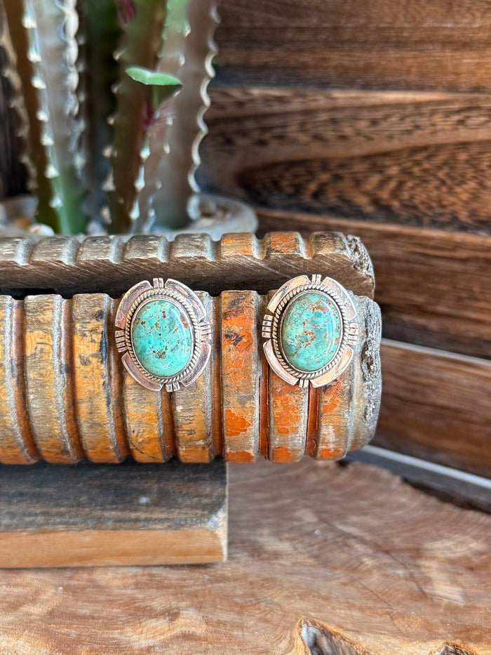 Round turquoise cabochon stud earrings in ornate silver bezel settings