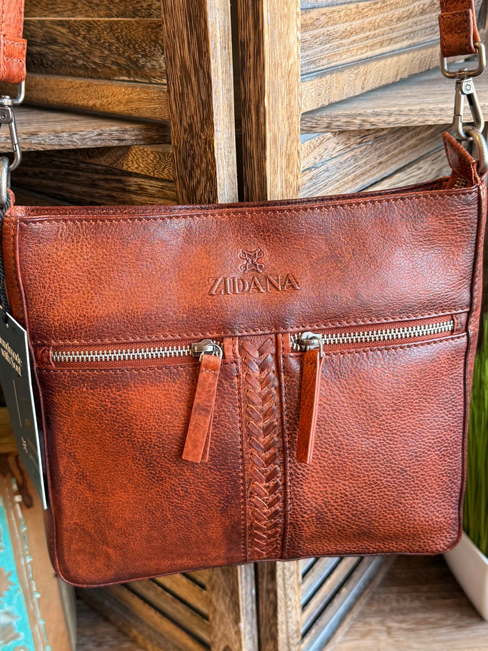 Rusty brown leather crossbody bag with double zip pockets and centered ZADANA logo