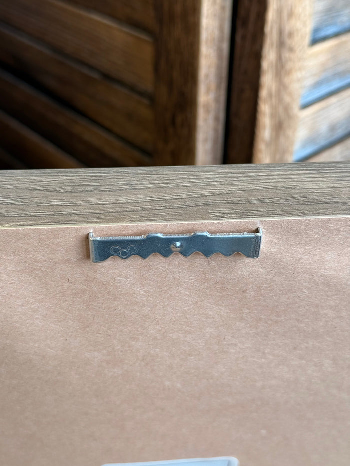 Metal hanging bracket on the back of a framed wall artwork