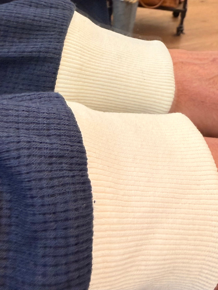 Waffle-knit fabric swatch: navy and off-white long-sleeve crew neck texture