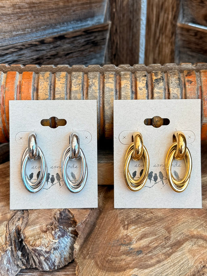 Double round stud earrings in silver: oval double-hoop studs on white display card