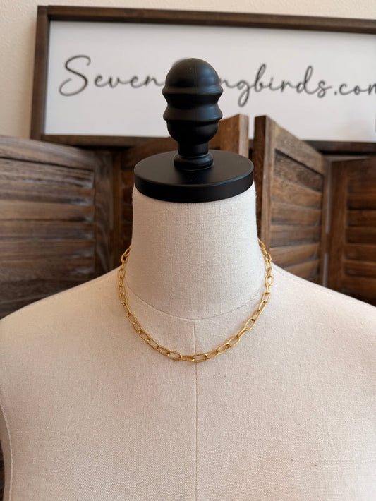 Gold-plated chain necklace with oval links on a display bust