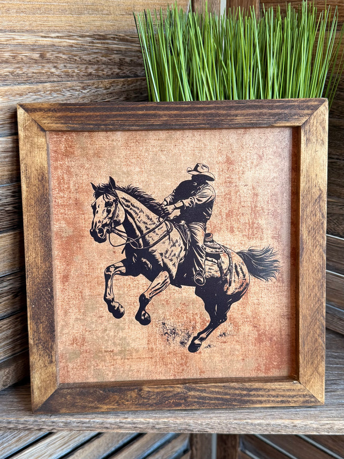 Framed cowboy on horseback artwork with two-tone black illustration, rustic wood frame