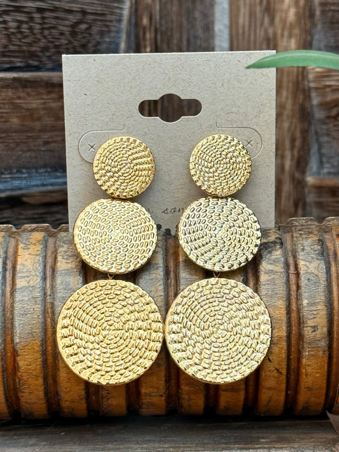 Triple round textured gold-tone drop stud earrings, three stacked circles visible on card