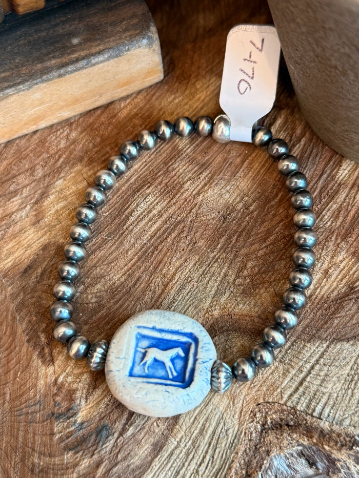 Beaded stretchy bracelet featuring blue horse ceramic focal disc with silver-tone beads