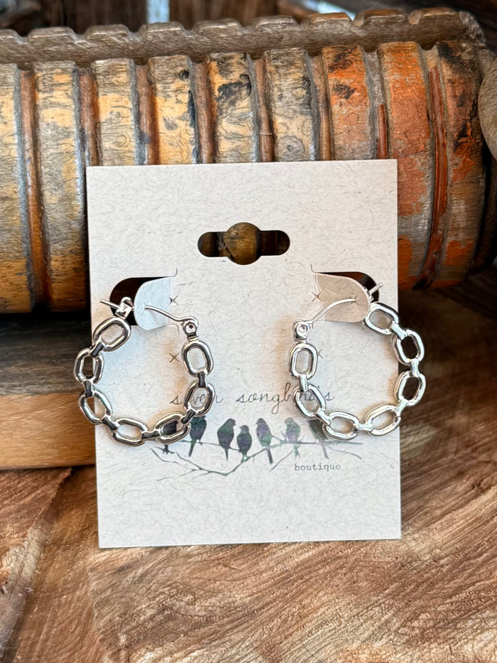 Silver-tone chain link round stud earrings set on jewelry display card