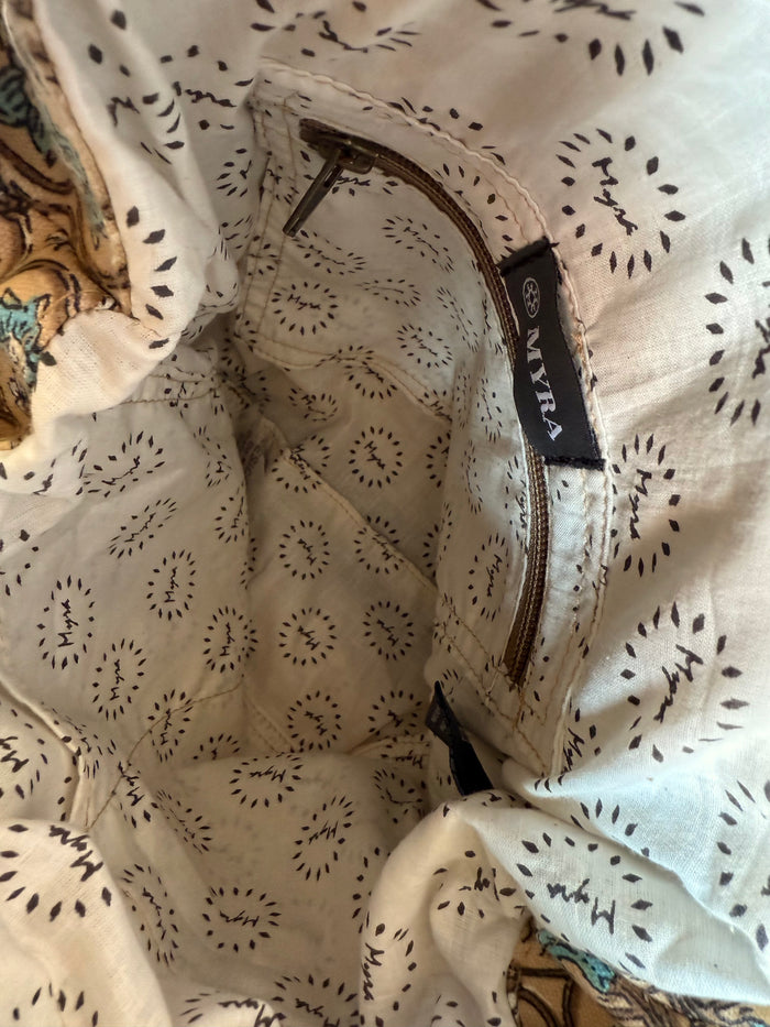 Printed canvas tote lining with internal brand label and tan zipper opening