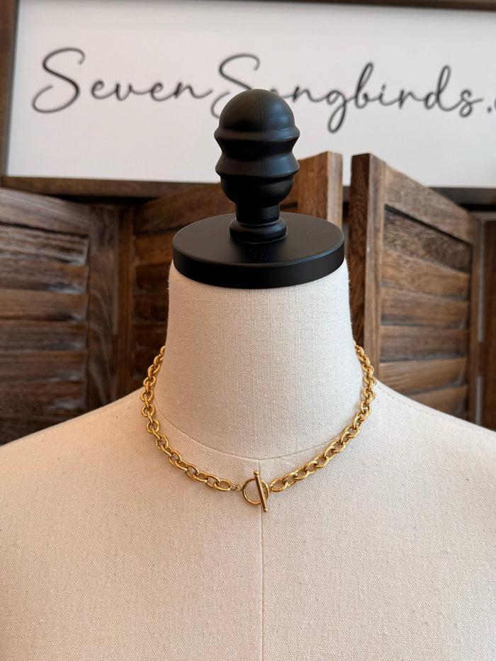 Gold chain necklace with small V toggle clasp, worn on mannequin neck