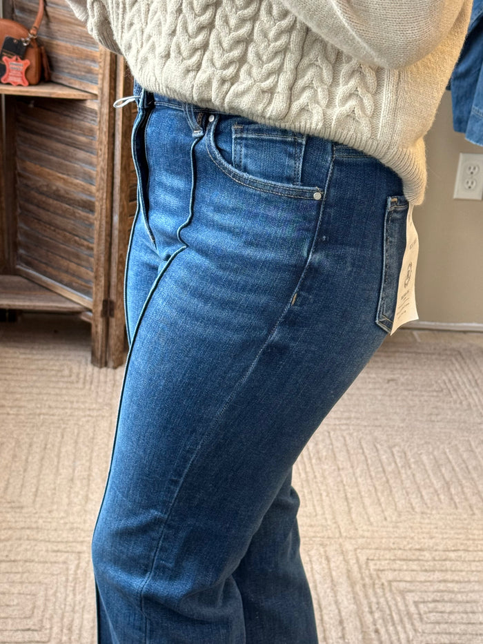 Front-seam dark blue jeans with light contrast stitching and cuffed ankle hem