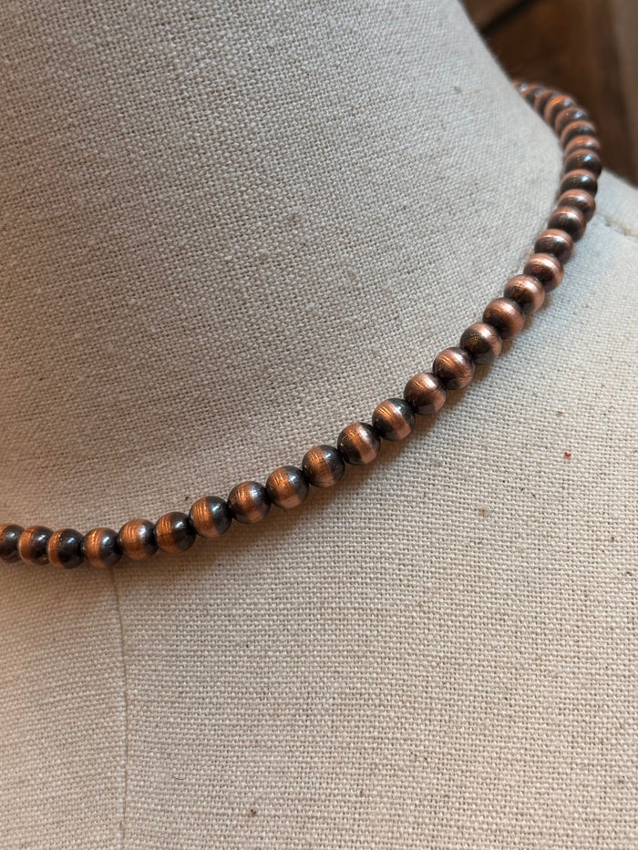 Close-up of round 6mm genuine copper beads on a bead necklace