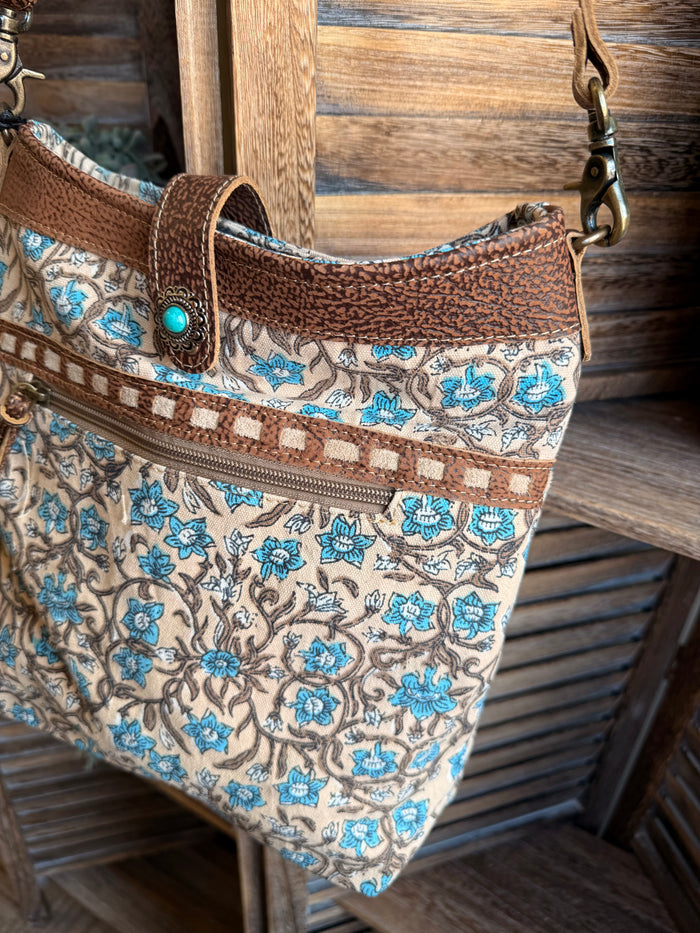 Floral canvas tote bag with tassel zipper pull, brown trim, turquoise button detail