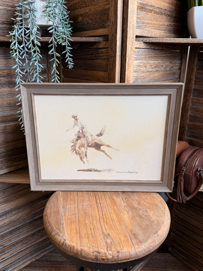 Framed cowboy and bucking horse wall art with beige mat and gray wood frame