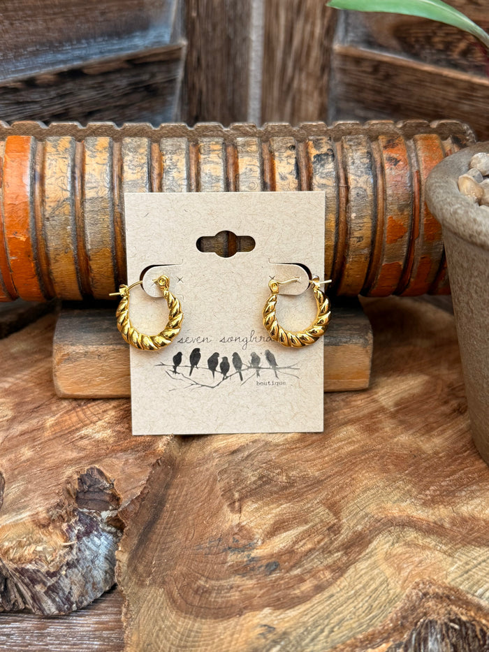 Twisted gold-tone hoop stud earrings, small crescent shape, on display card