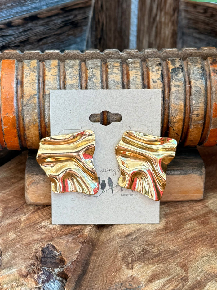 Gold-plated square textured stud earrings, close-up on display card