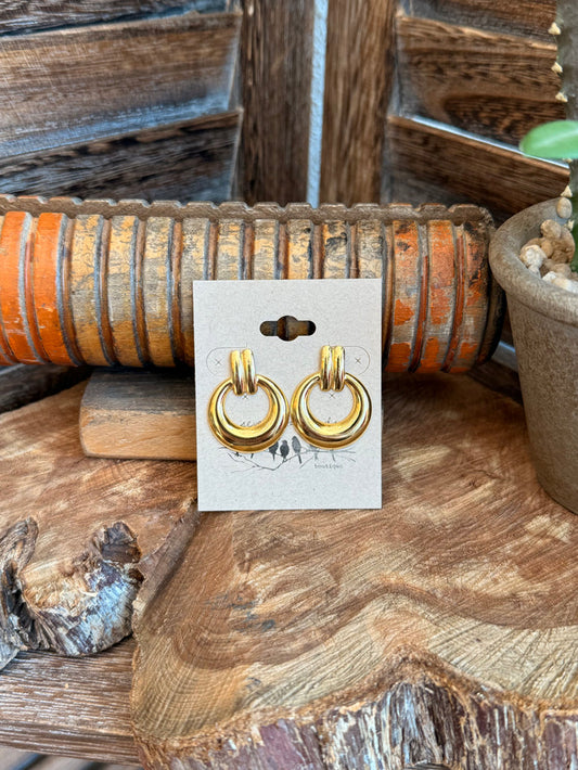 Gold-tone hoop stud earrings with circular loops, shown on display card
