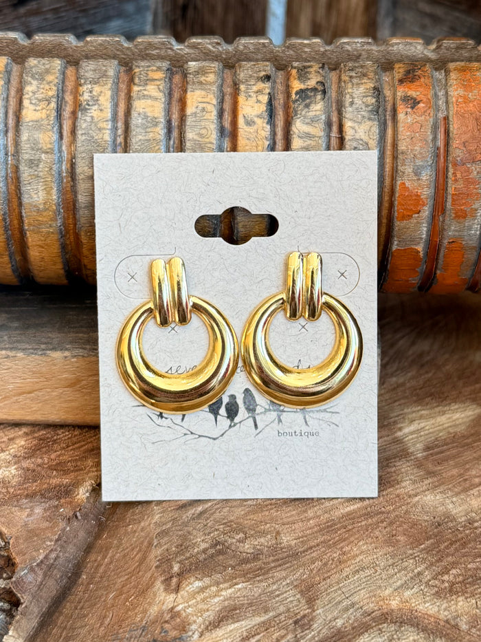 Gold-tone circular hoop stud earrings, close-up on display card