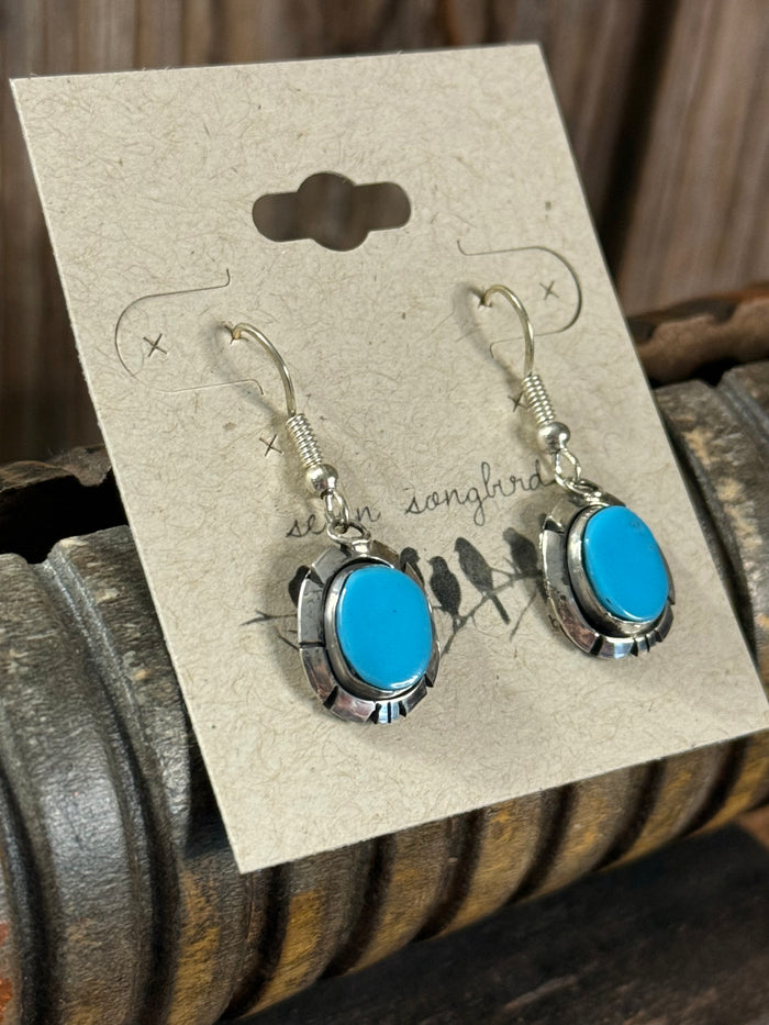 Turquoise oval fishhook earrings with scalloped silver-tone frames and dangle hooks