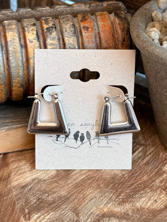 Silver trapezoid drop earrings with smooth metal frames and small dangling details
