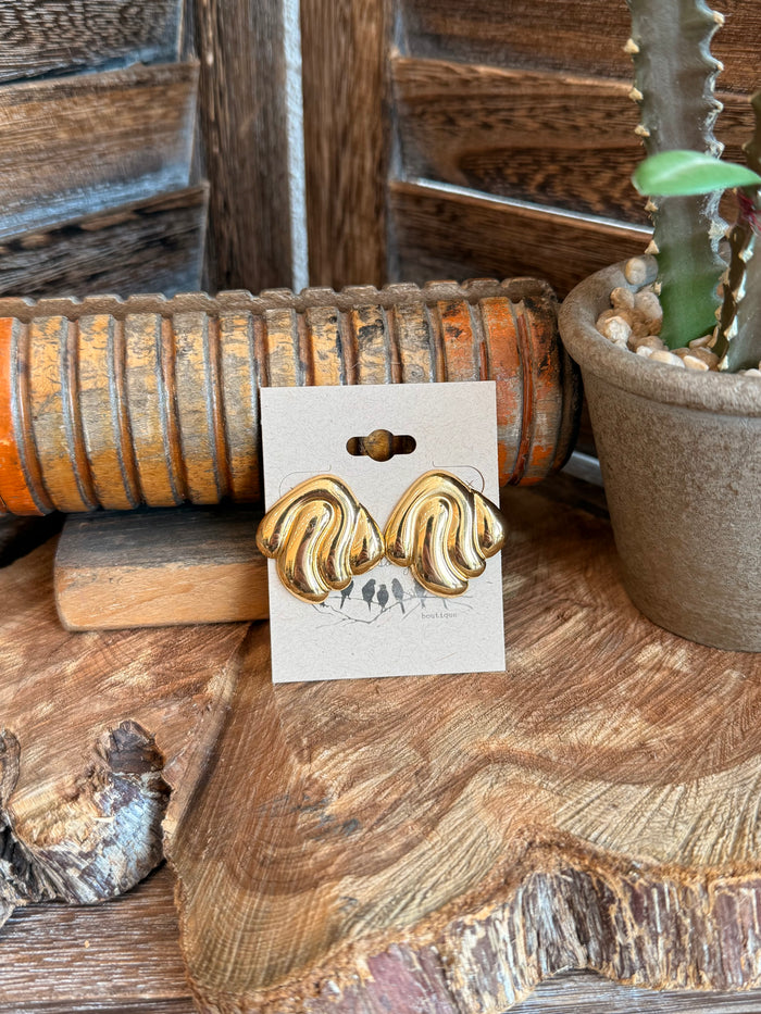 Gold wavy stud earrings in stainless steel with curved swirl fronts, pair on cards
