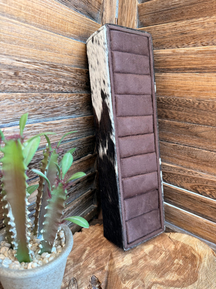 Cowhide ring display box with mauve padded panel and segmented insert, upright stand