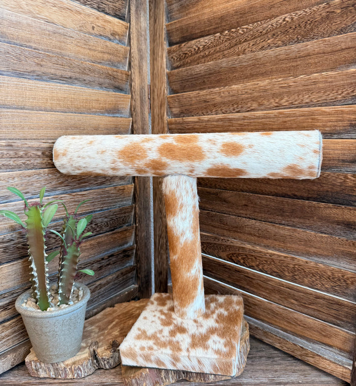 Cowhide bracelet display stand with tan-and-white cowhide top bar and square base