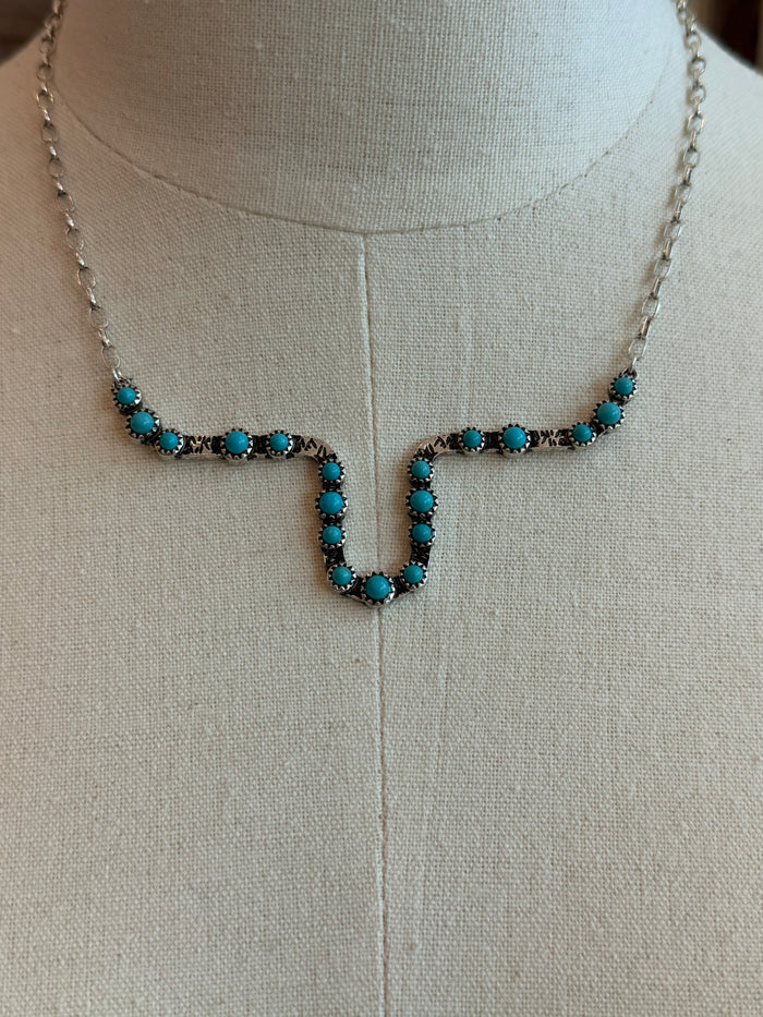 Turquoise beaded longhorn outline pendant with gold-tone chain links close-up