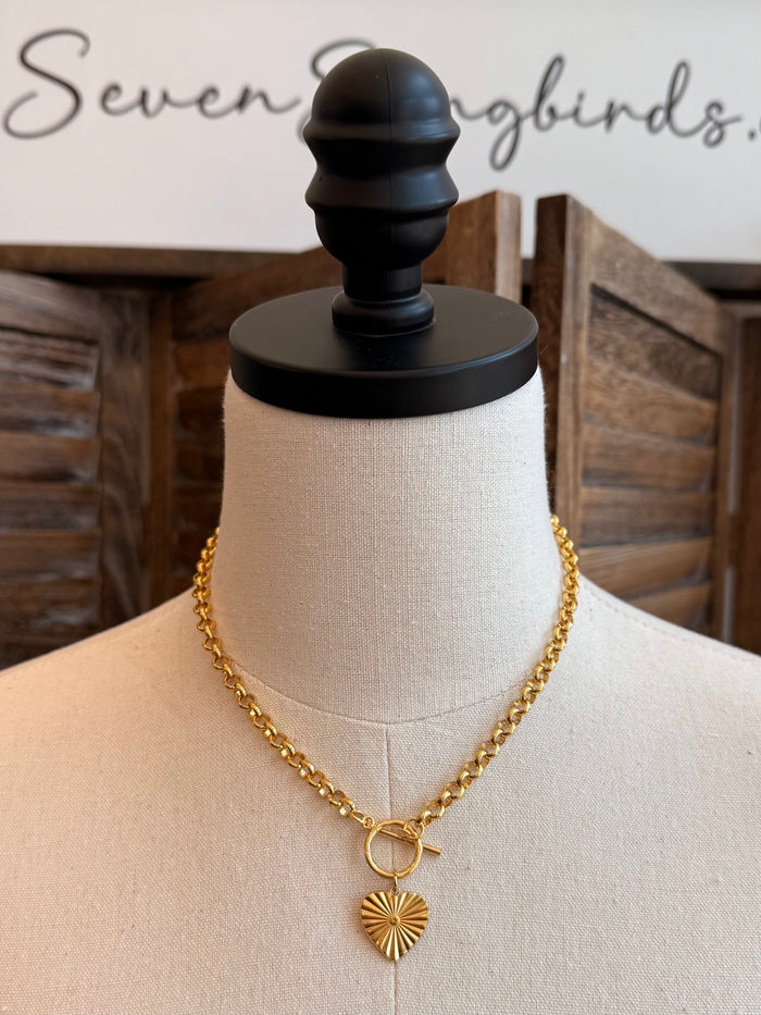 Gold-tone chunky chain heart pendant necklace with toggle clasp and sunburst heart charm