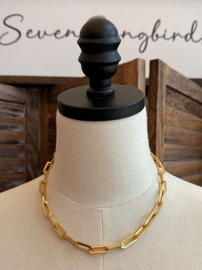 Gold-plated chunky chain necklace on mannequin, elongated oval link pattern