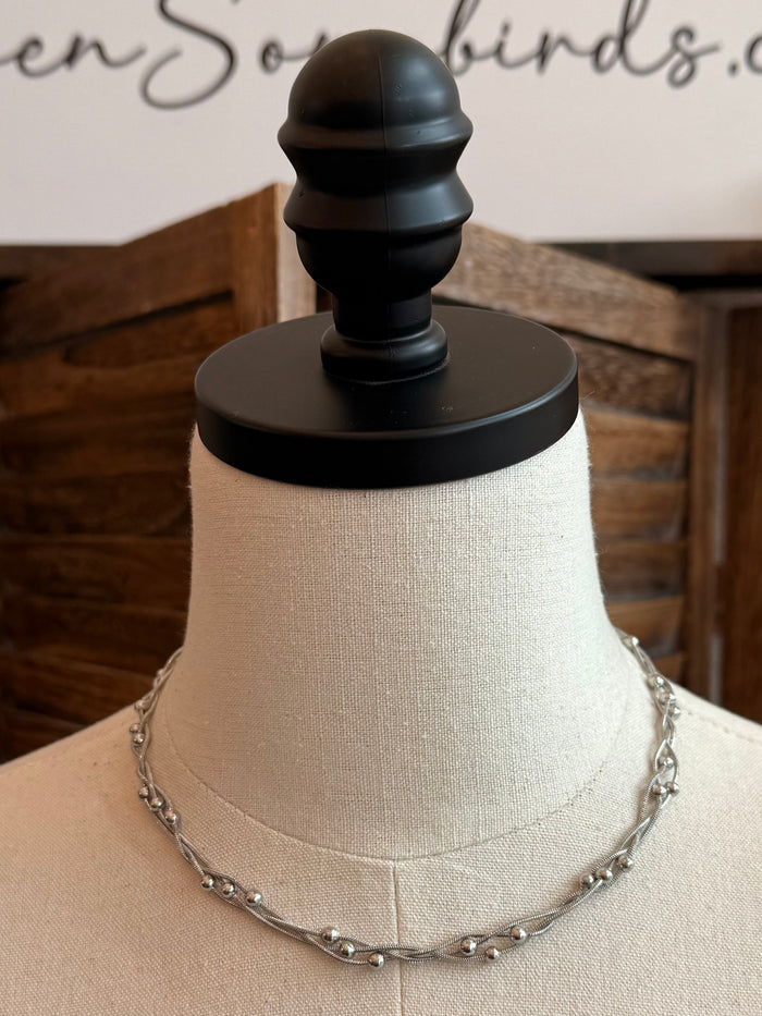 Stainless steel weaved chain necklace on a mannequin with rounded link beads