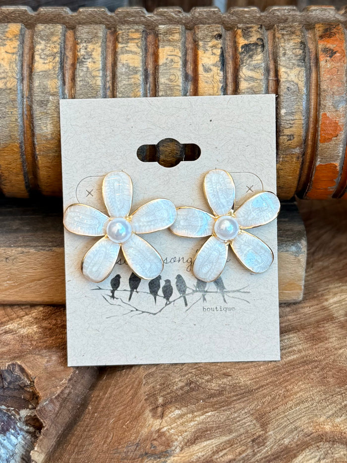 Front view of white pearl flower stud earrings with gold-tone posts and dark tassel drops