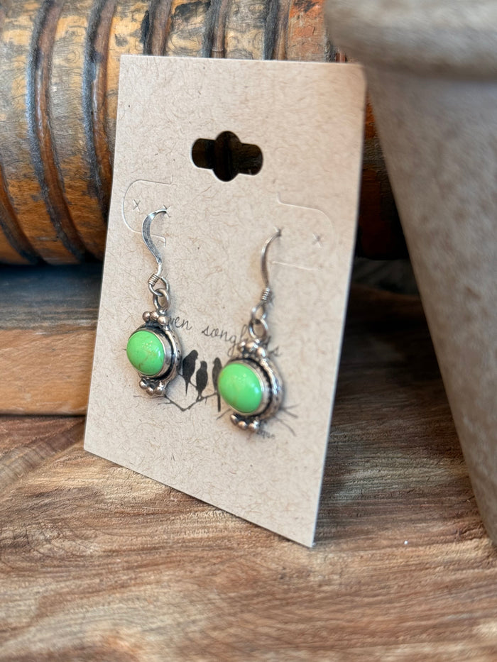 Sterling silver fishhook earrings with green oval gemstone and dangling charm accents