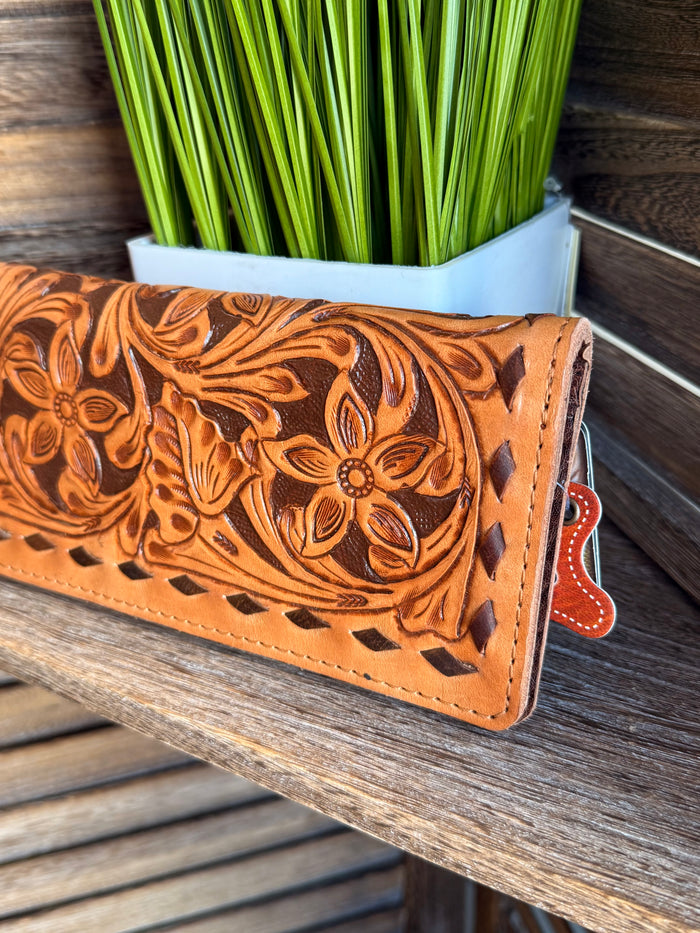 Tooled leather bifold wallet in orange-brown with floral tooling and snap closure