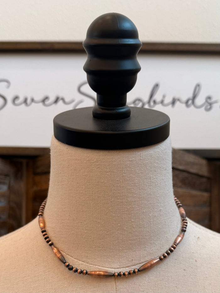 Copper torpedo bead necklace on mannequin with black and copper beaded cable