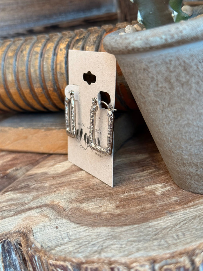 Silver textured trapezoid stud earrings shown from the side, with metal backs